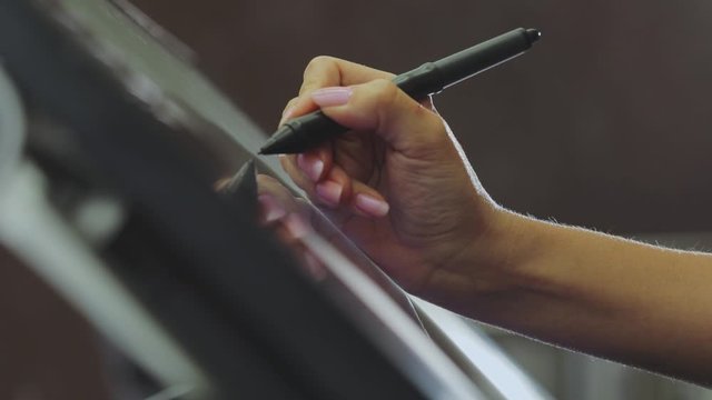 The designer draws on a graphics tablet. Working with interactive pen display. Drawing on a graphics tablet. closeup. Wallpaper production.