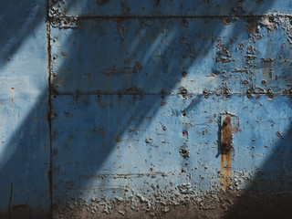 青く塗装された錆びた鉄の扉