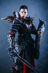 Fototapeta premium Portrait of a medieval female knight in armour over blue background.