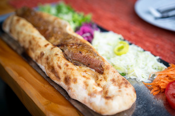 Meat with bread on a plate with a salad on the side