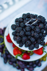 Black raspberries, strawberries and grapes arranged in plates