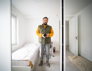 Young man taking selfie in a minimalistic bedroom