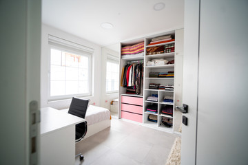 A shot of a white bedroom with an open wardrobe