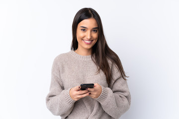 Young brunette woman over isolated white background sending a message with the mobile