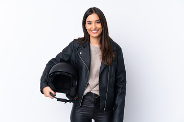 Young brunette woman with a motorcycle helmet over isolated white background smiling a lot - obrazy, fototapety, plakaty