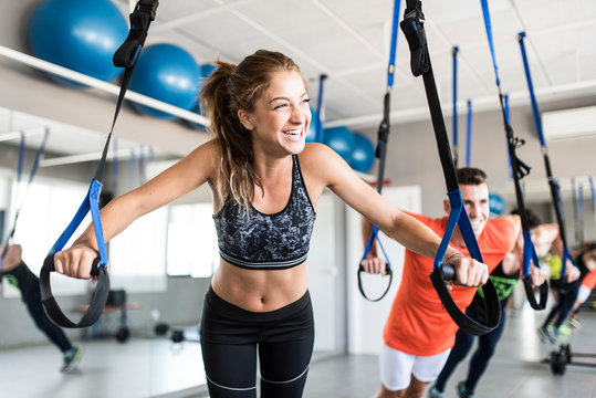 People at gym doing elastic rope exercises at cross fit room