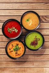 flat lay of cream vegetable soups on wooden table
