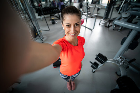 Young fit woman taking selfie in gym