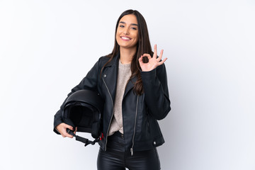 Young brunette woman with a motorcycle helmet over isolated white background showing ok sign with fingers