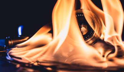 A photo lens shrouded in flames