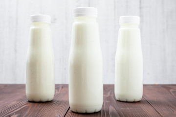 Bottles with milk, yogurt on a light background. Natural dairy products.