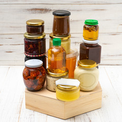 Various canned foods in jars on a light wooden background. Organic food.