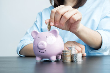 Women's hands are putting coins in the piggy bank Saving money with coins Step into a business that is growing to be successful and save for retirement ideas