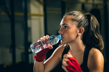 woman kickboxing drinking water in gym