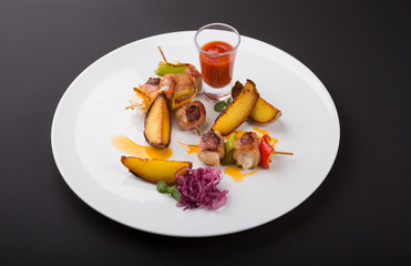 Chiken with bacon served on skewer