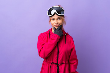 Skier teenager girl with snowboarding glasses over isolated purple background thinking