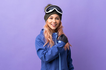 Skier teenager girl with snowboarding glasses over isolated purple background celebrating a victory