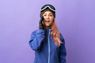 Skier teenager girl with snowboarding glasses over isolated purple background shouting with mouth wide open