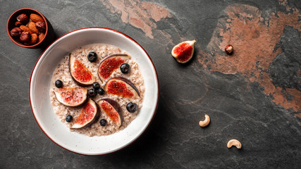 Delicious and healthy oatmeal with figs, blueberries and chia seeds. Healthy breakfast Gluten, lactose free, Fitness food. Long banner format, top view