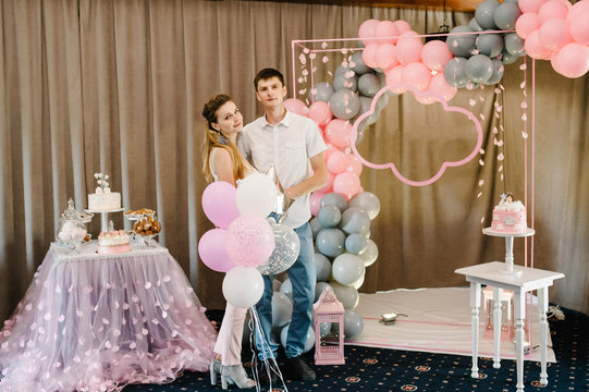 Hugging and enjoying couple, spending time together while celebrating Saint Valentine's Day in hand air balloons on the background party, birthday. Happy joyful family. Love.