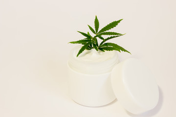 cannabis in a jar with cream on a white background