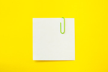 note sheet with paper clip on yellow background