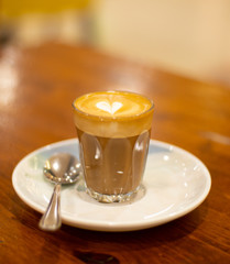 Glass of Coffee Piccolo Latte on a wooden table