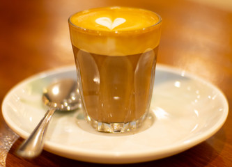 Glass of Coffee Piccolo Latte on a wooden table