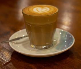 Glass of Coffee Piccolo Latte on a wooden table