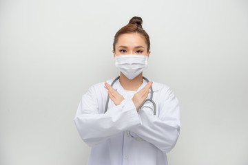 Serious-looking asian female doctor in medical mask, white coat make stop, cross sign, forbid coming outside