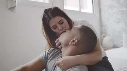 Happy interracial couple in love kissing at their bedroom