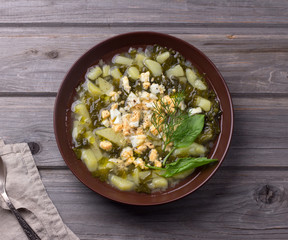 Summer simple sorrel soup with egg on wooden background, flat lay