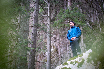 Obraz premium Experienced hiker sitting on rock taking a break from hiking