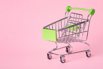 Empty top view mini pink shopping cart or trolley shopping on pink background