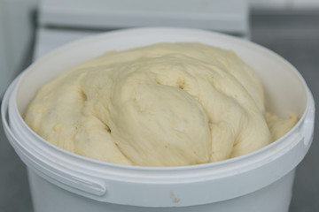 Fresh dough ready for baking in plastic basket. Preparation of bakery products