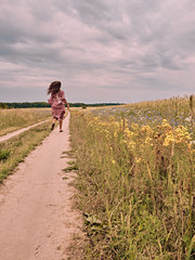 girl runs along the road. landscape