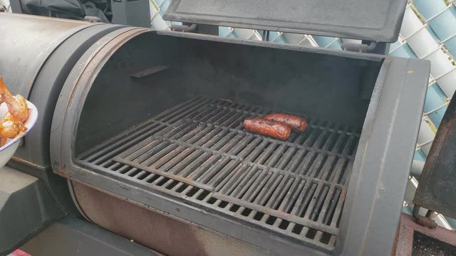 Home cooking - Placing sausage and chicken wings in the smoker for extra smoky flavor after being previously barbecued  and cooked in gas grill