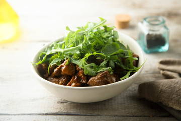 Homemade beef ragout with fresh arugula