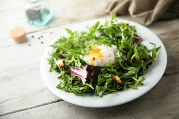 Healthy arugula salad with poached egg