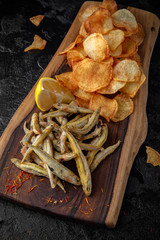 Fototapeta premium Smelt fish with chips and lemon. Crispy delicious seafood beer snack.