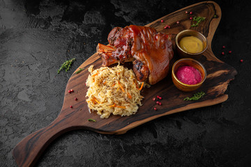 Baked pork leg served with stewed cabbage and sauces