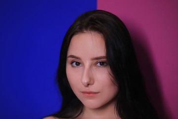 emotional portrait of a brunette girl on a pink-blue background