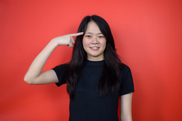 Portrait of Young beautiful asian woman using black T-shirt with red isolated background