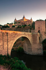 View of Alcantara Bridge and the Alzacar from Toledo, capital of La Mancha, Spain.