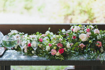 Wedding flowers, roses, chrysanthemums, decorations, bouquets, glasses on the table close-up. Festive accessories and details.