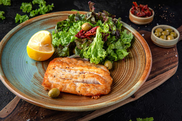 Fillet fish fried in batter and salad of fresh vegetables and herbs