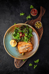 Fillet fish fried in batter and salad of fresh vegetables and herbs