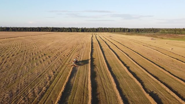 tractor with tedder collects hay in one line