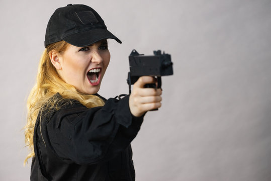 Woman holds gun in hands.