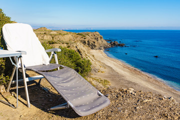 Empty camp chair on cliff, coast in Spain